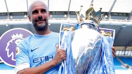 Pep Guardiola celebrates with the Premier League trophy