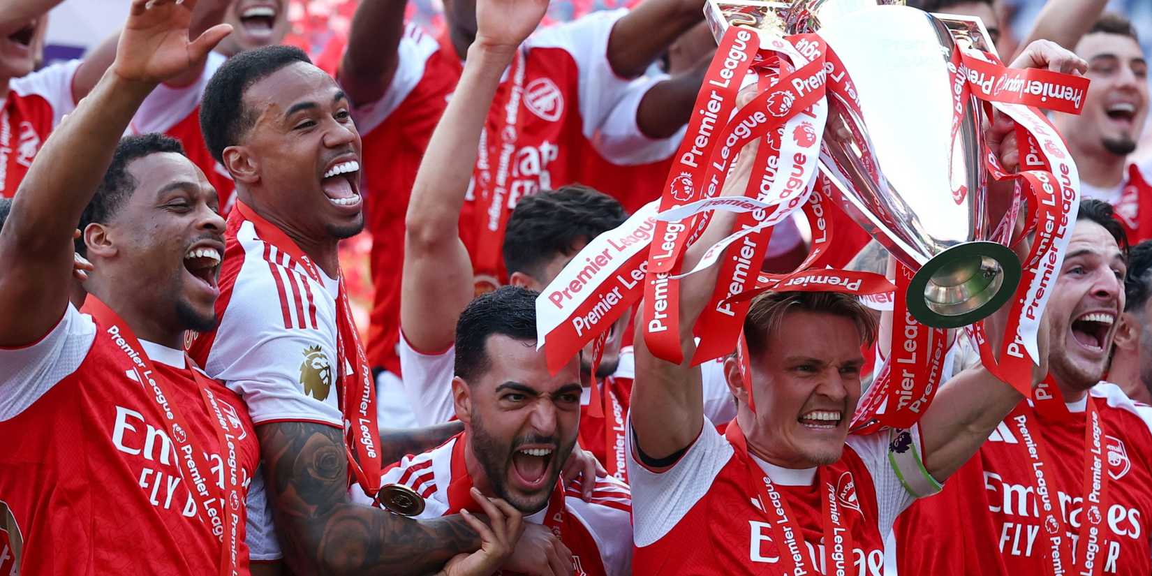 Arsenal's Martin Odegaard lifts the trophy as he celebrates with teammates after winning the Premier League