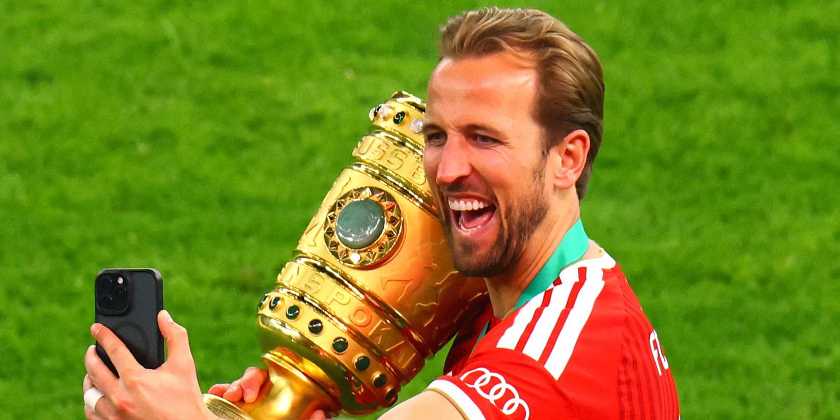 Bayern Munich's Harry Kane takes a selfie with the trophy as he celebrates winning the DFB Cup
