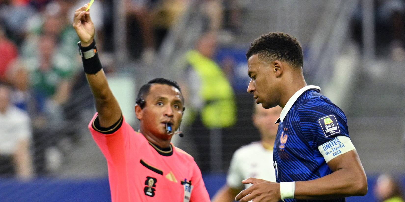 France's Kylian Mbappe is shown a yellow card by referee Ivan Barton