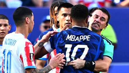 Referee Ilgiz Tantashev reacts with France's Kylian Mbappe after players clash