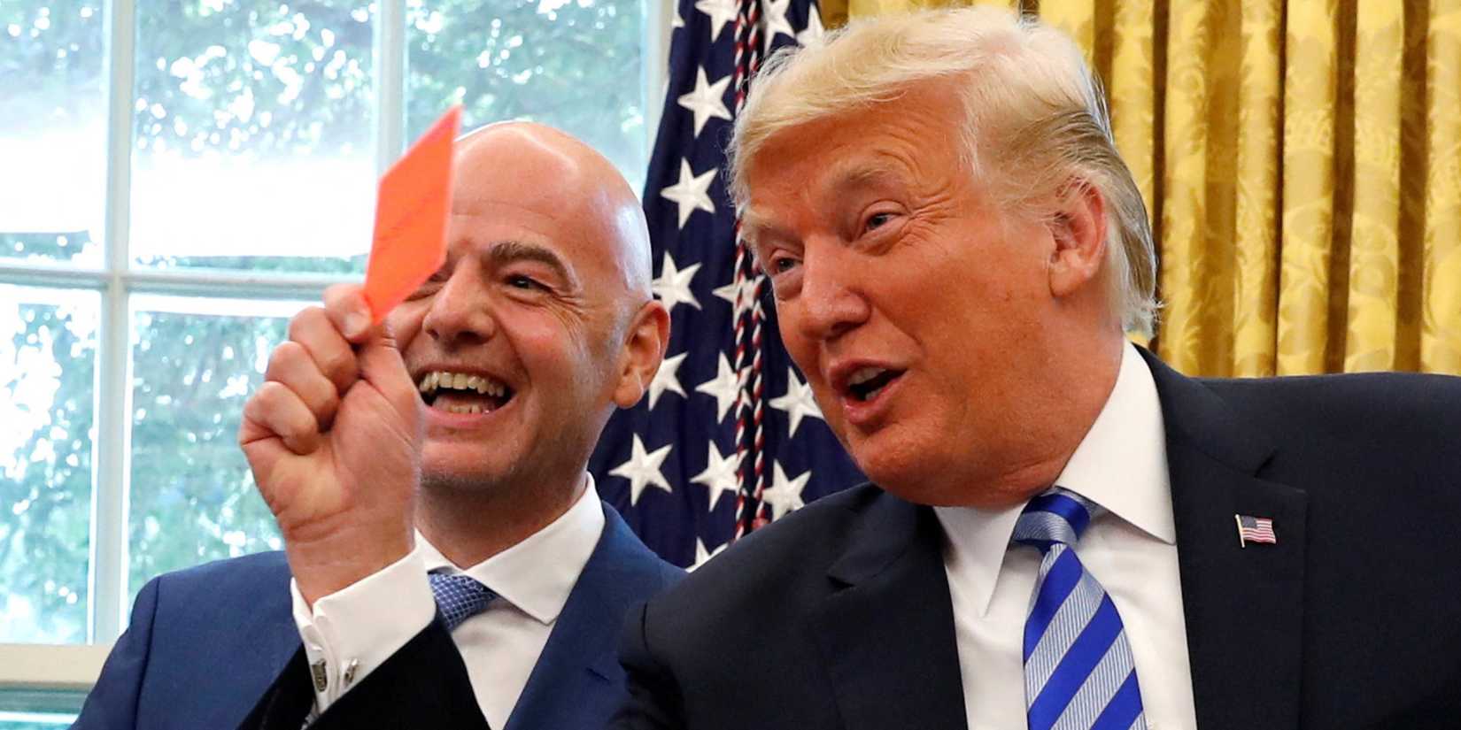 Donald Trump holds up a red card as he meets with FIFA President Gianni Infantino