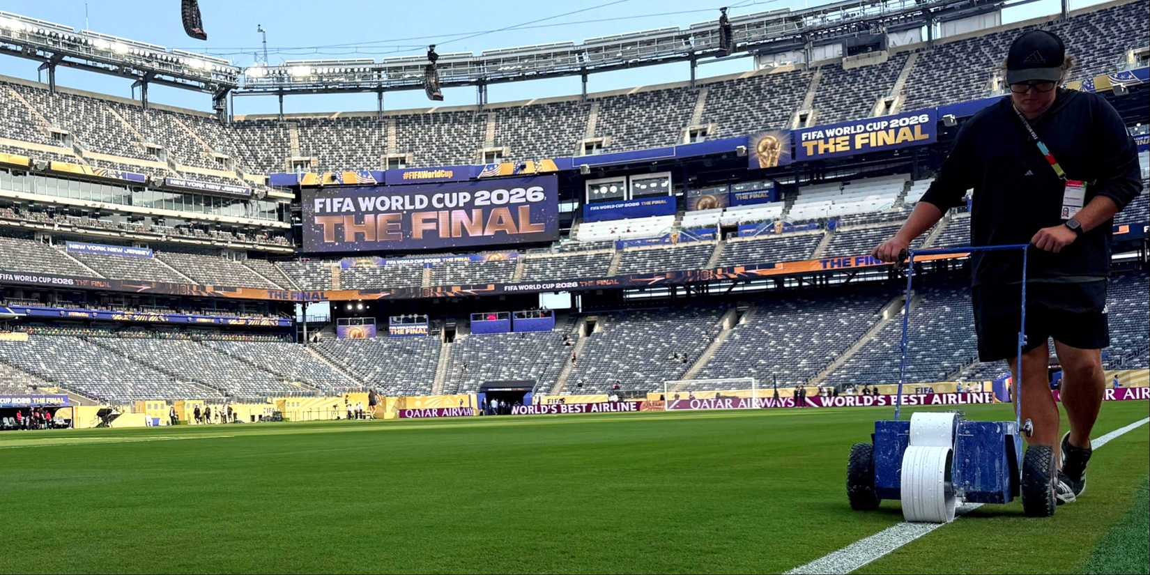 A member of groundstaff paints the pitch lines inside the stadium before the World Cup final
