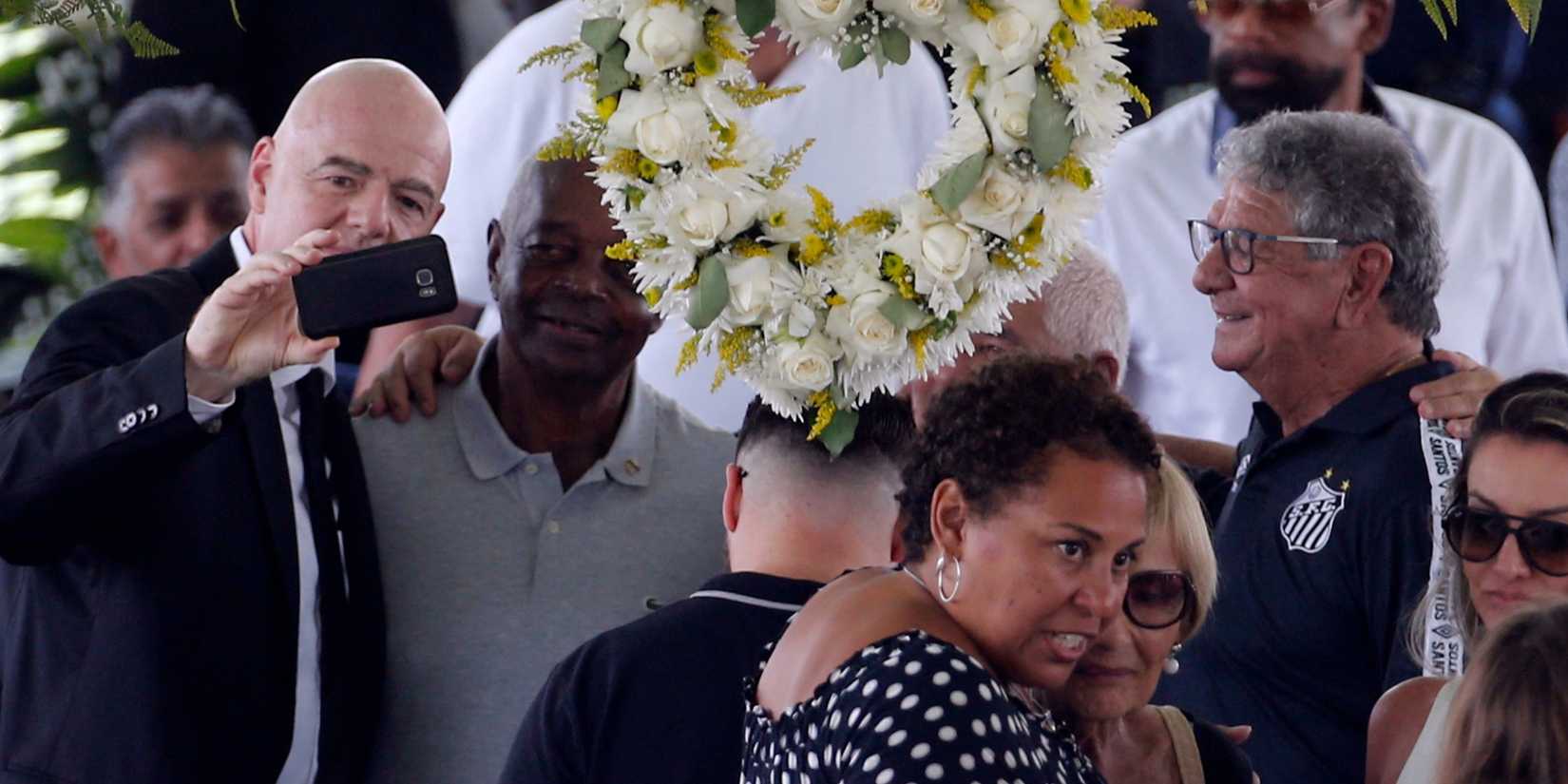 FIFA president Gianni Infantino takes a selfie, and Pele's daughter, Kelly Cristina Nascimento is pictured with mourners as the body of Brazilian soccer legend Pele is just out of sight in his casket